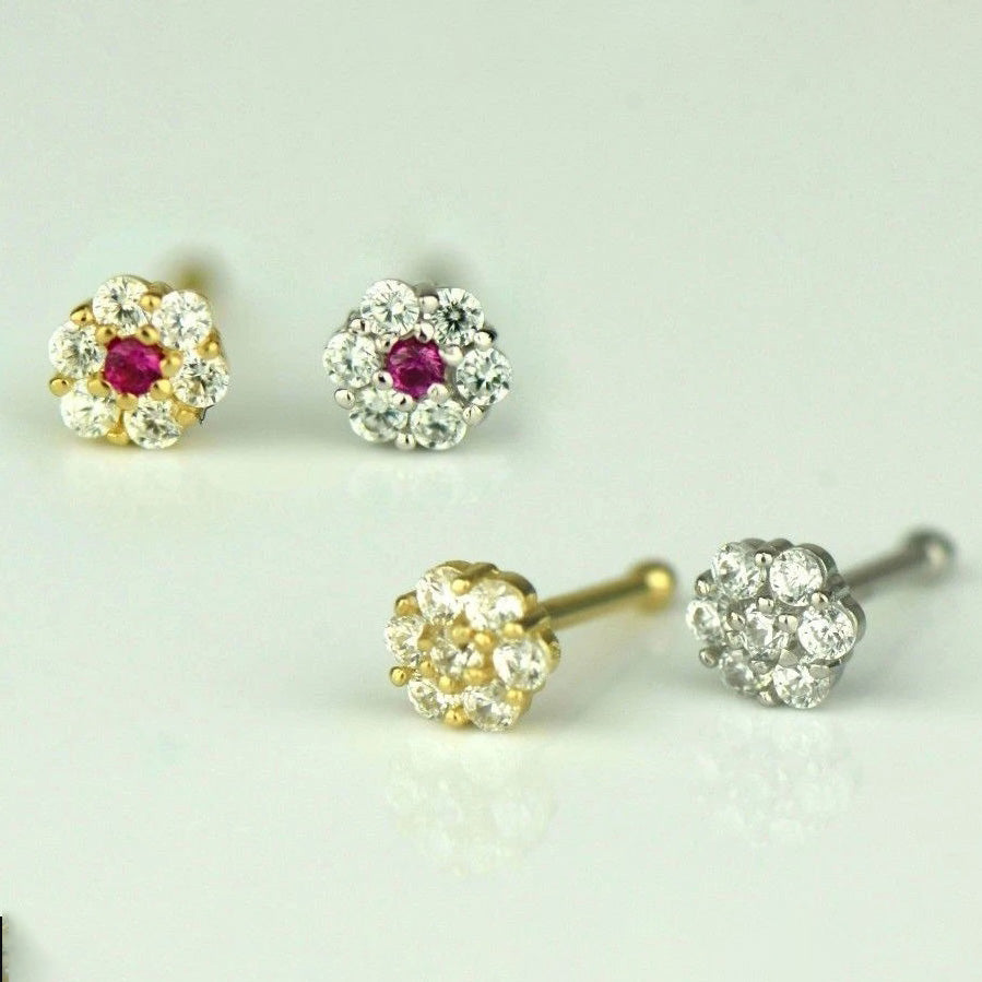 Pair of gold and silver earrings with gemstones on a light gray background