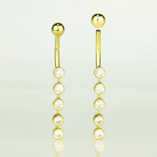 Gold earrings with clear gemstones on a light gray background